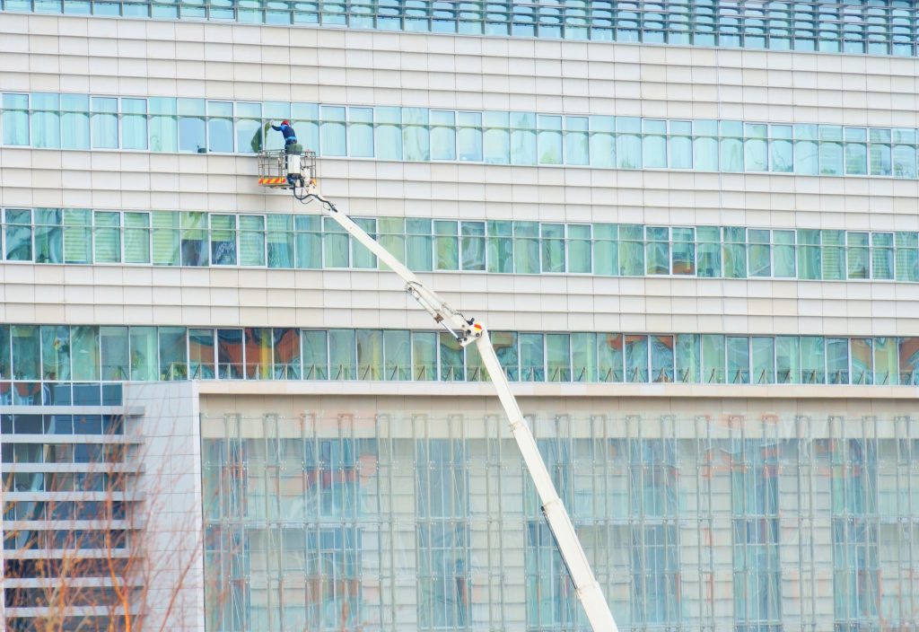 cleaning the windows of the facade of an office building using a lifting mechanism
